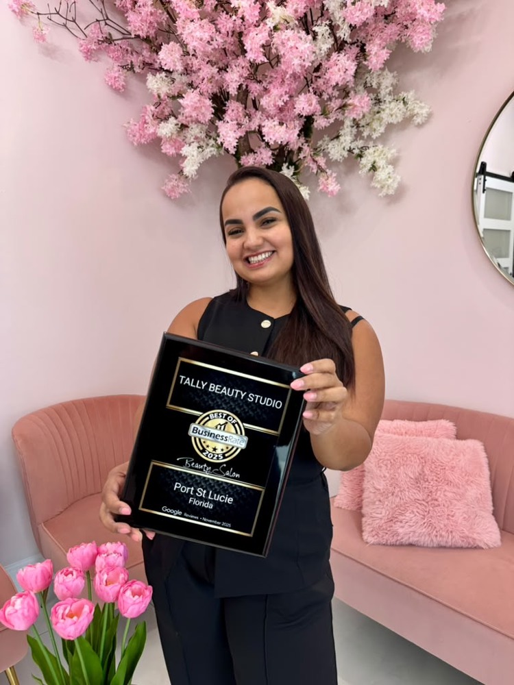 Tally, owner of Tally Beauty Studio, holding the Best of BusinessRate award for Best Beauty Salon in Port St. Lucie
